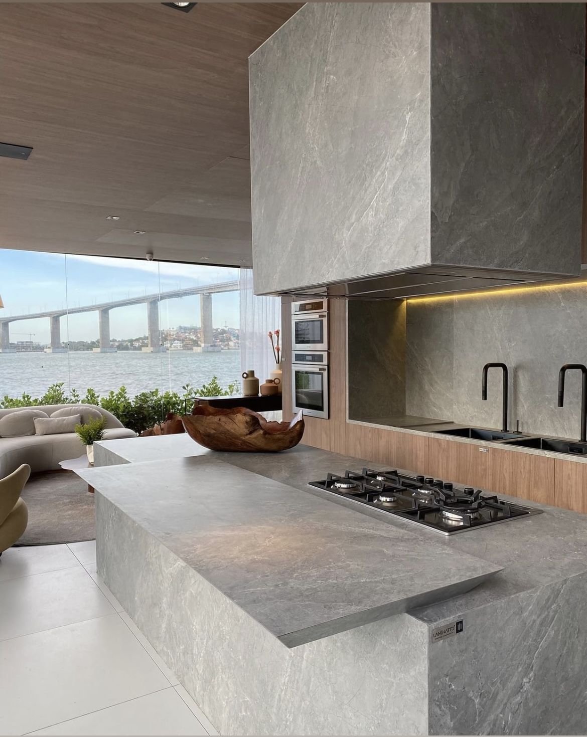 Cozinha com bancada em pedra natural e vista para o mar